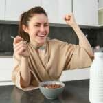Teenage girl with a bowl full of protein doing strong gesture representing foods for strong bone health