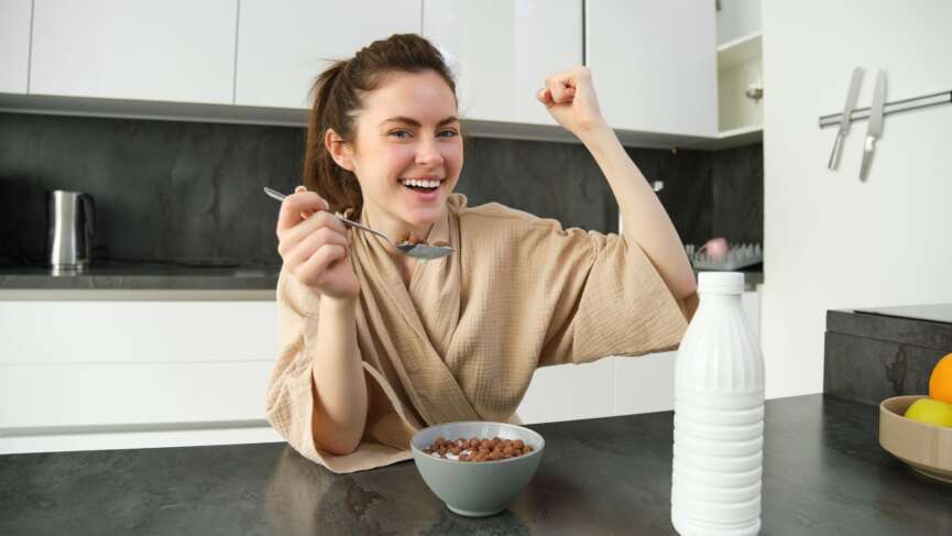 Teenage girl with a bowl full of protein doing strong gesture representing foods for strong bone health