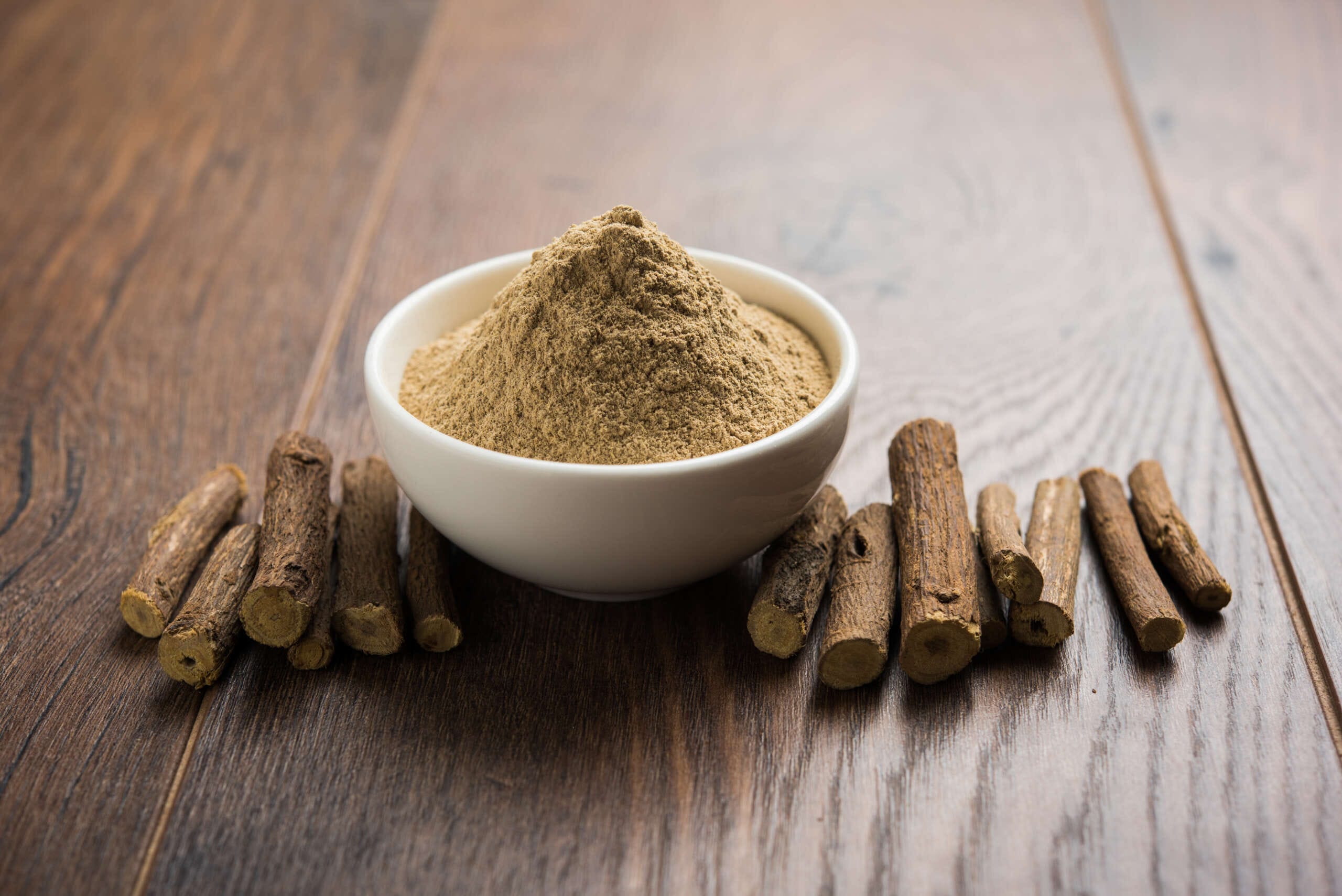 Ayurvedic ashwagandha and Liquorice root stick or jeshthamadh powder served in a bowl over moody background and impact of health benefits of ashwagandha